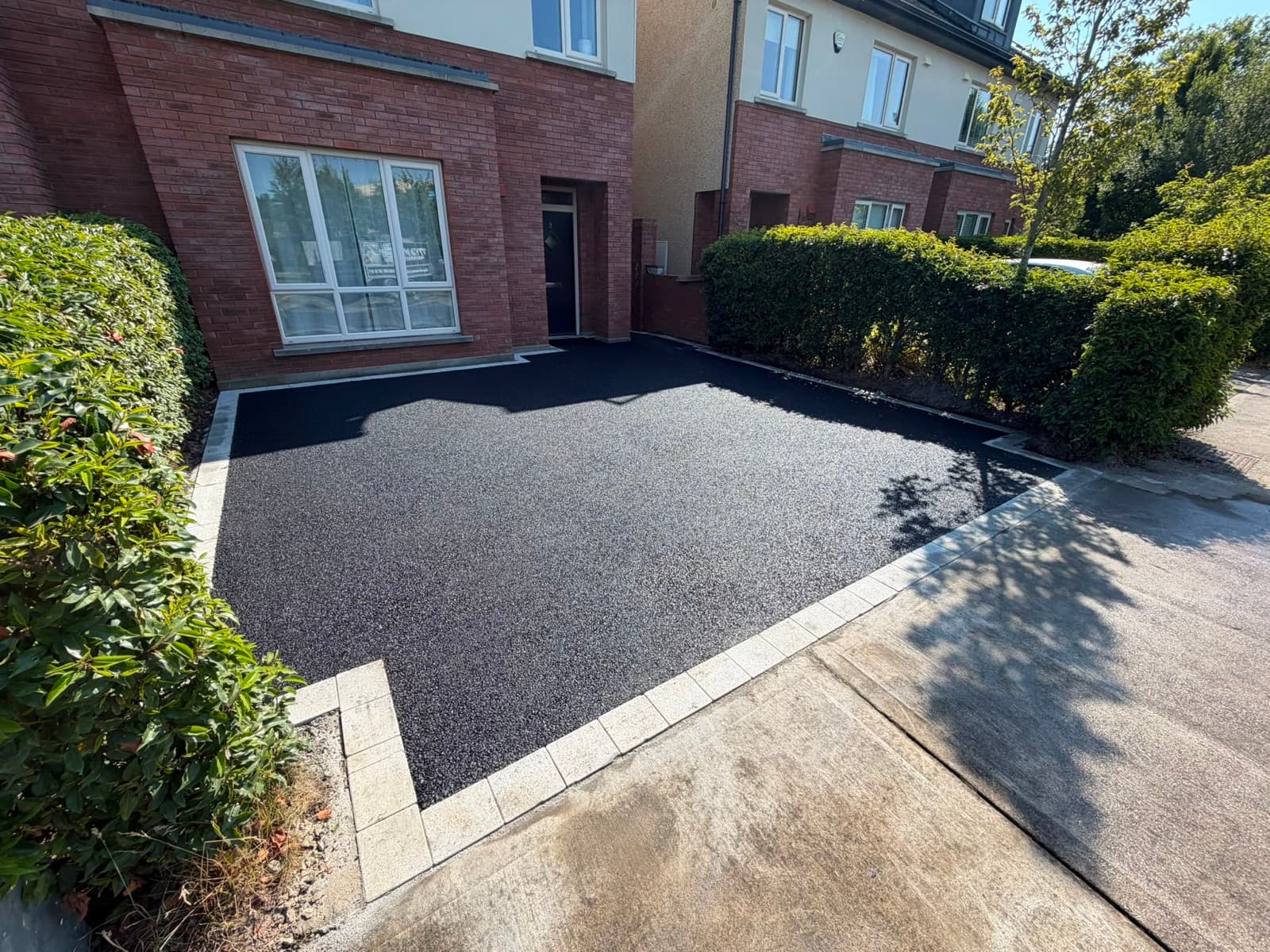 Tarmac driveway to a red-brick home